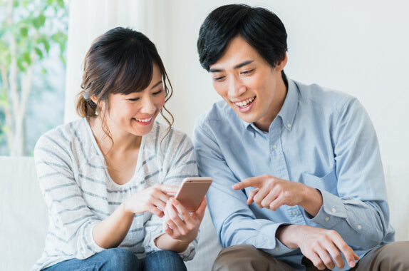 スマホを見ながら業者選びをする夫婦